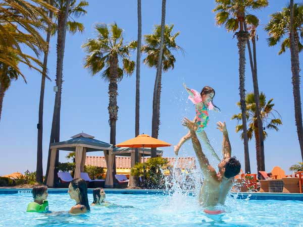 Dad throwing daughter in the pool.