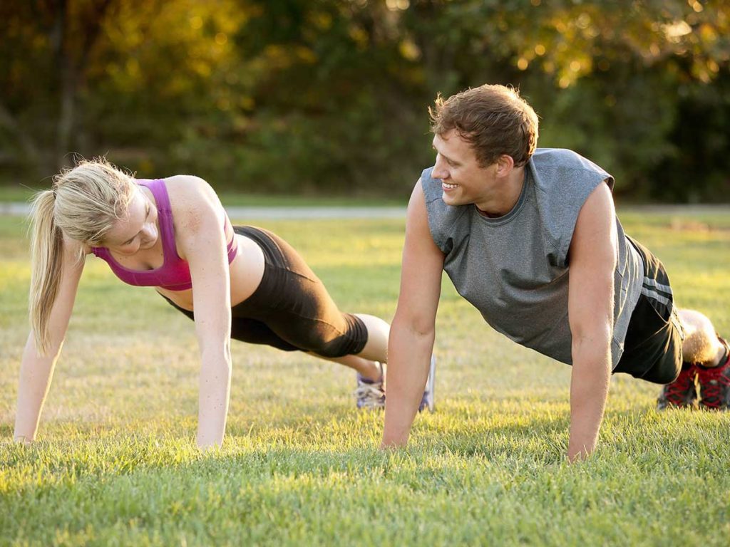 Couple doing Lawn exercises and workout in San Diego Mission Bay