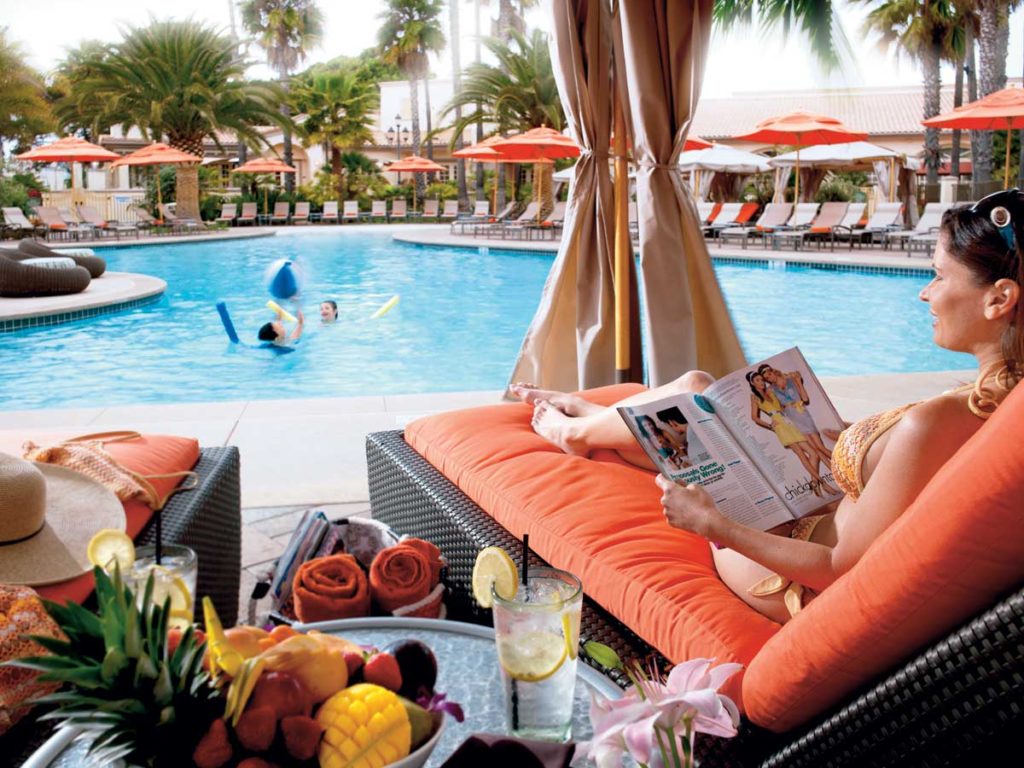 Woman in beach cabana at San Diego luxury private pol