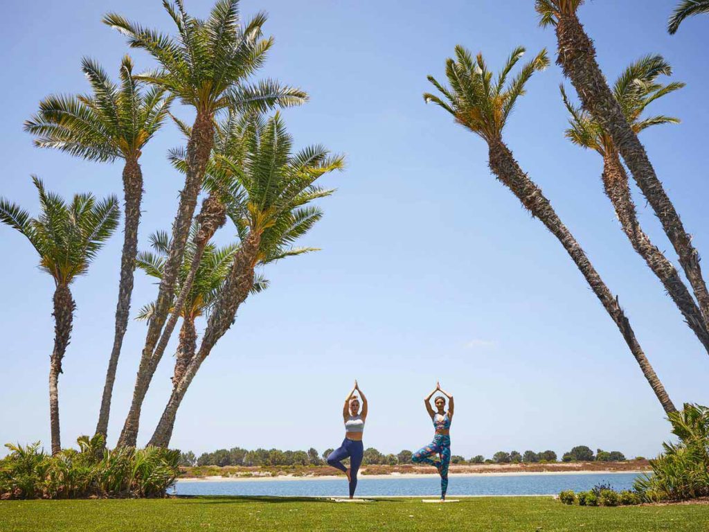 People doing yoga on the beach.