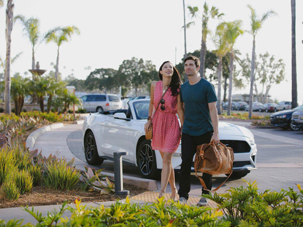 Couple with white car behind