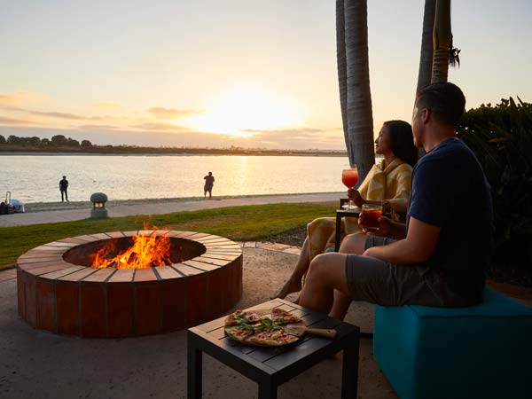 Couple Having Food And Drinks By The Firepit.