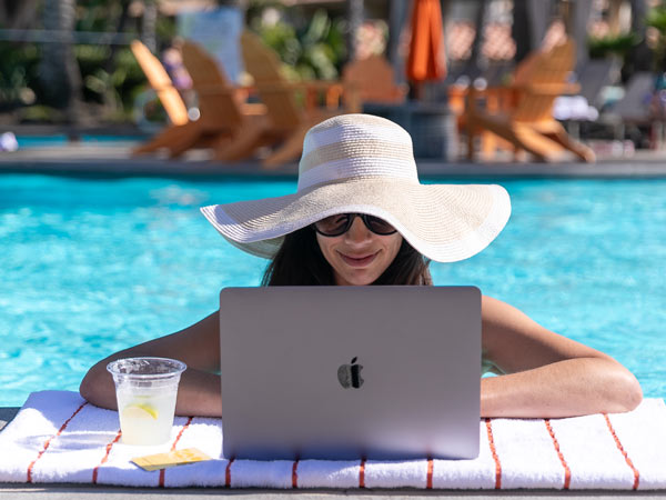 Lady Working On A Computer In The Pool