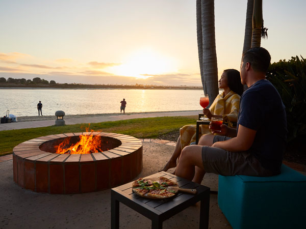 Couple Eating Pizza By A Firepit