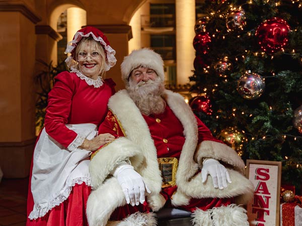 Santa And Mrs Clause By The Christmas Tree