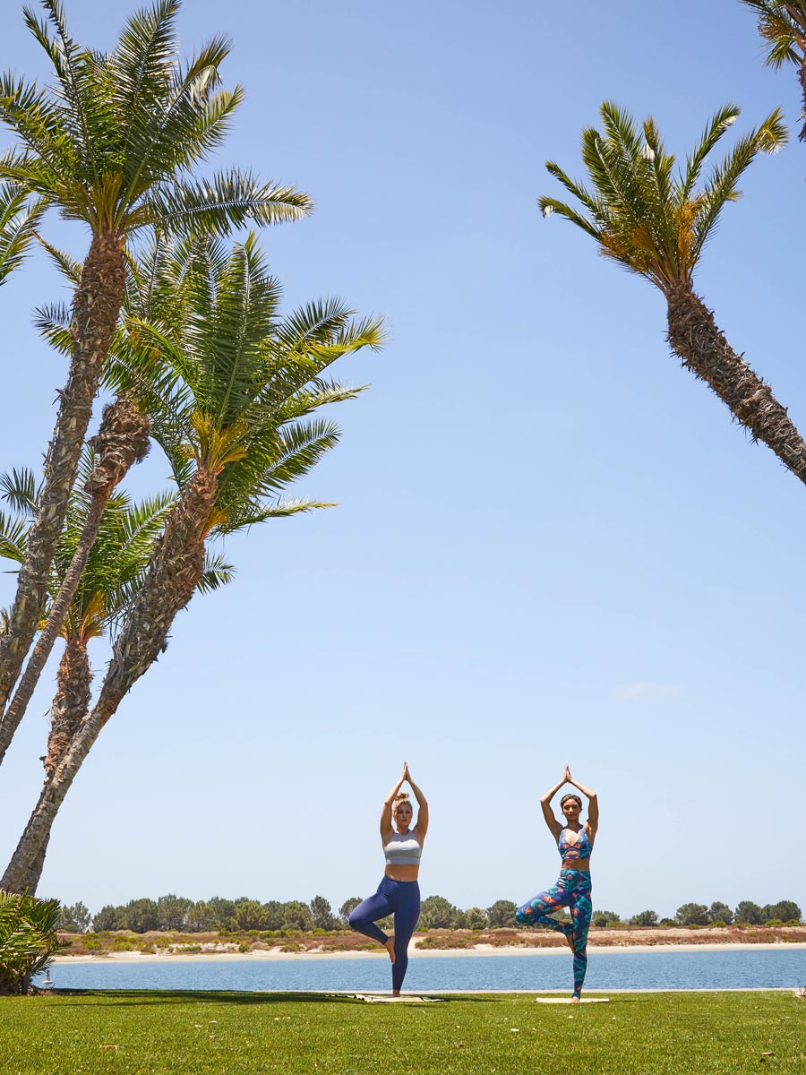 People doing yoga on the beach.