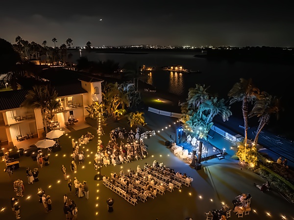 Evening live concert on the bayfront lawn with seated guests and a lit stage at San Diego Mission Bay Resort, overlooking the water and San Diego city lights