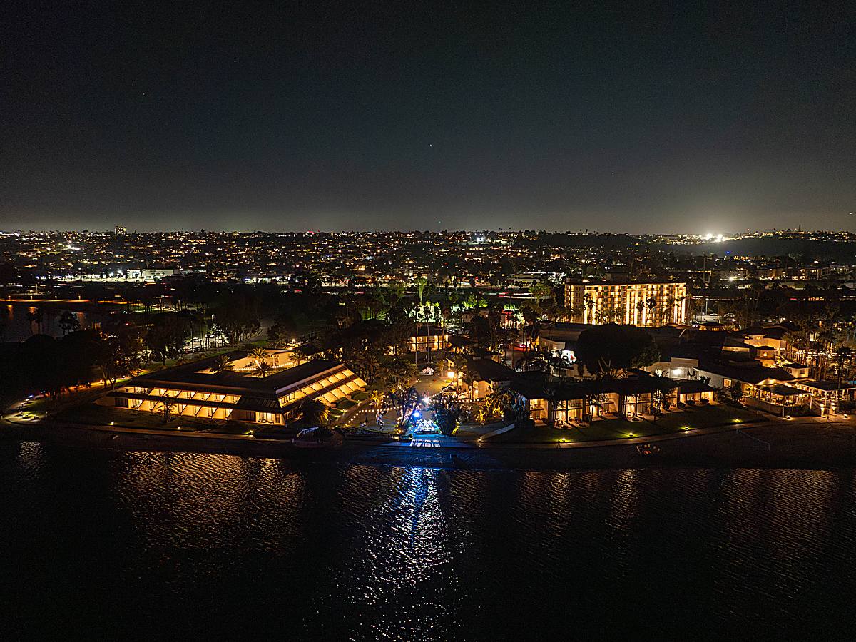 San Diego Mission Bay Resort lit up at night with bayfront accommodations and tropical landscaping reflected in Mission Bay