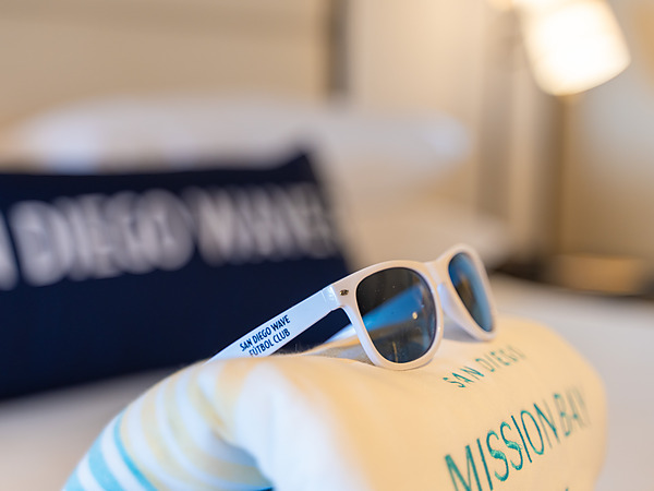 San Diego Wave FC sunglasses on a San Diego Mission Bay Resort towel and pillow.