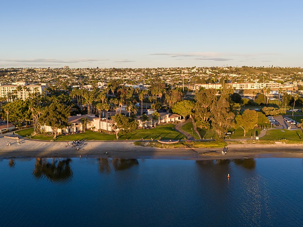 Aerial view of San Diego Mission Bay Resort's bayfront beach at sunset.