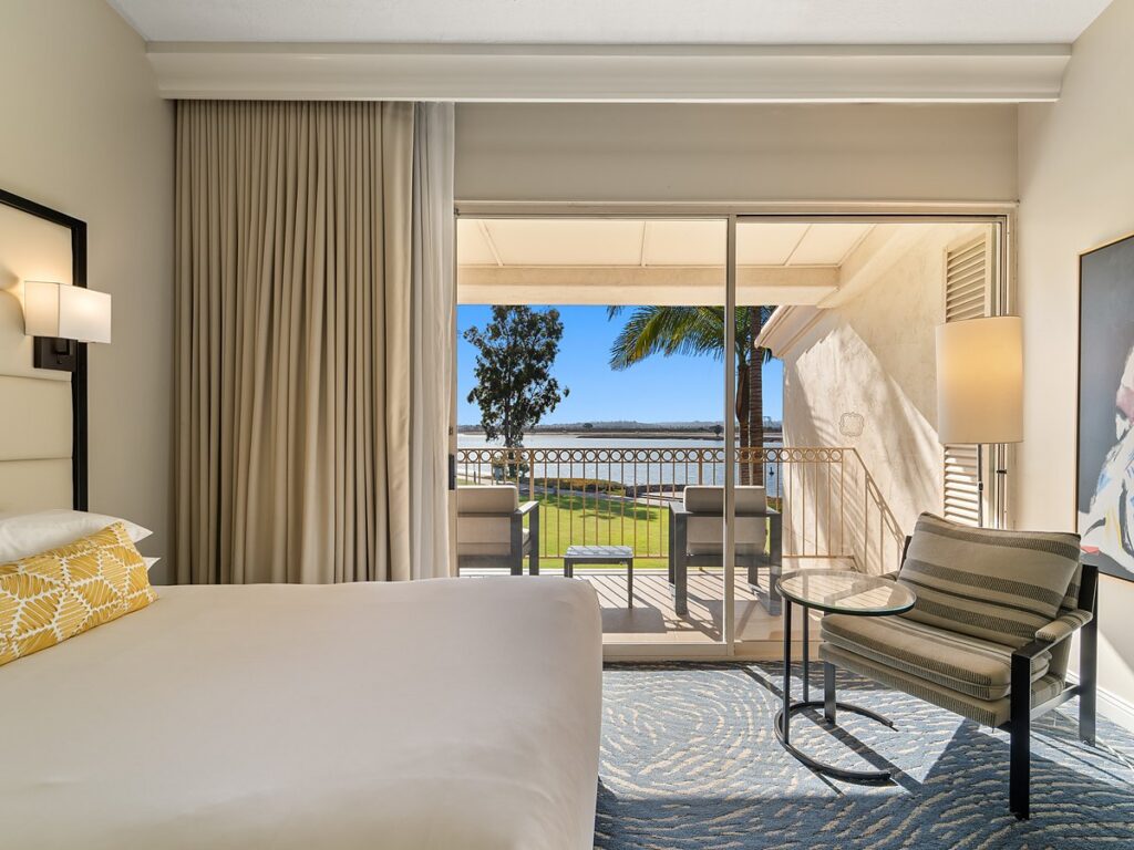 San Diego Mission Bay Resort guest room with king bed and balcony overlooking Mission Bay.