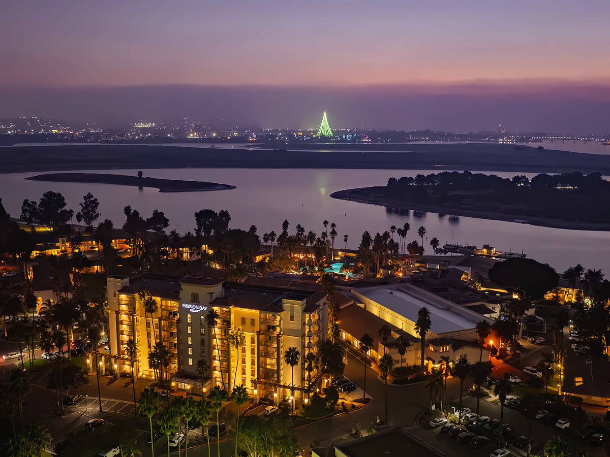 Aerial twilight view of San Diego Mission Bay Resort with holiday lights across Mission Bay.